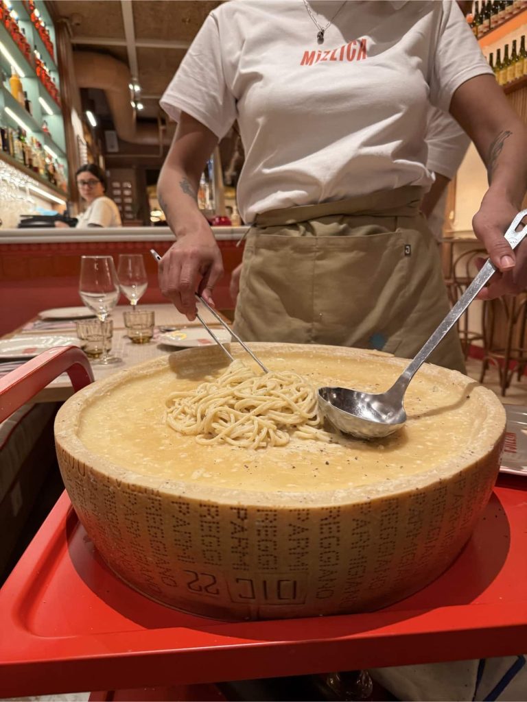 Cacio e pepe servido en rueda de parmesano